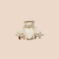 Heart-shaped hair clip with wings held by a hand against a neutral background