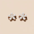 Pearl flower hair clip held by a hand against a neutral background